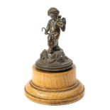 A 19th century bronze study of Cupid: on a domed base with female mask decoration,