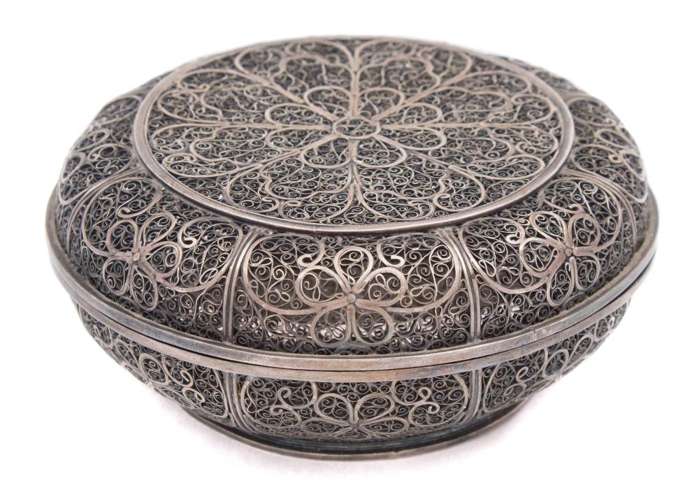 An Indian silver filigree circular box: decorated with flowerhead and scrolling motifs, 11cm.