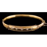A late 19th century 15ct gold and diamond hinged bangle: with five square-set round old
