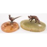 Two early 20th century cold painted bronze mounted onyx ashtrays:, one with a figure of a pheasant,
