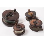 A group of four mahogany and brass star backed reels:, unsigned , various sizes and condition..