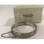 A silver hinged bangle complete with safety chain and original box.