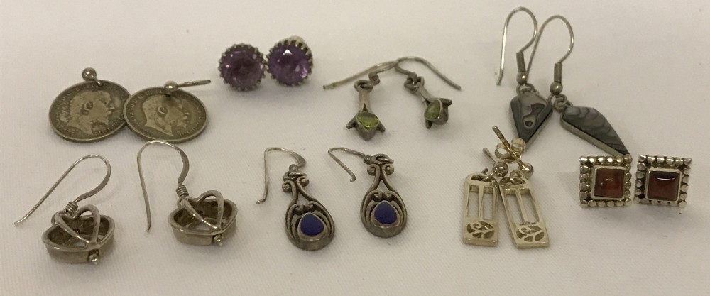 8 pairs of silver and white metal earrings. Some stone set.