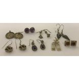 8 pairs of silver and white metal earrings. Some stone set.