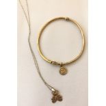 A 9ct gold thin bangle with small circular cherub charm.