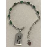 A 925 silver bracelet with alternate wave style silver links and varying shades of green stones.