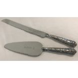 A silver handled bread knife and pie server with queens patterned handles.