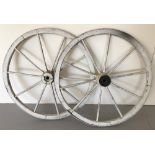 A pair of white painted vintage cart wheels.