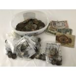 A tub of assorted vintage foreign and British coins, tokens and bank notes.