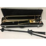 A HK Trombone kit with hard carrying case, spare mouthpiece and trombone stand for stage use.