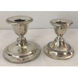 2 silver candlestick holders with filled bases.