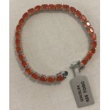 A 925 silver tennis bracelet set with 29 oval cut orange topaz stones.