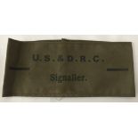 A WW2 style printed armband, marked "U.S. & D.R.C. Signaller".