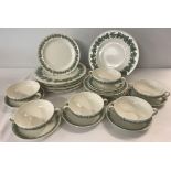 A quantity of vintage Wedgwood Queensware embossed dinner ware in cream and green colours.