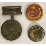2 Vietnam War Era N.V.A/Vietcong badges and a medal found in a street market in Saigon.