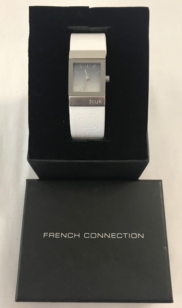 A ladies boxed French Connection wristwatch with white leather strap.