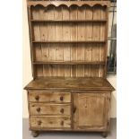 A Victorian pitch pine welsh dresser on bun feet.