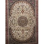 A Keshan pattern rug; beige background with red, blue and gold colouration.
