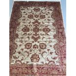 A Ziegler pattern rug; beige background with red and gold colouration.