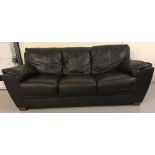 A modern 3 seater dark brown leather sofa on square wooden feet.