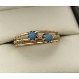 Ladies gold tri band style dress ring set with 2 turquoise stones. Tests as 22ct gold.