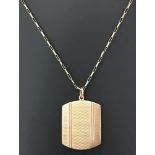 A vintage 9ct gold locket with engine turned decoration to front on a 18 inch box chain.