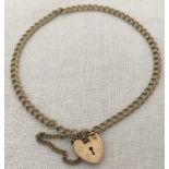 A 9ct gold curb chain charm bracelet with padlock and safety chain.