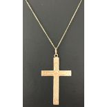 A 9ct gold cross pendant on a fine curb chain. Engraved detail to front of cross.