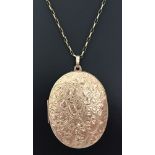 A large 9ct gold oval locket with front floral decoration. On a 26 inch 9ct gold cable chain.