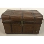 A large vintage tin trunk with painted woodgrain design and original catch.