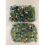 A tub of mixed vintage and modern marbles to include comet examples.