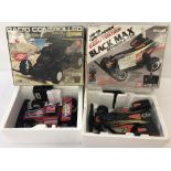 2 boxed vintage battery operated remote control off-road racer cars.