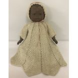 A reproduction ceramic head and hands black baby doll.