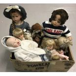 A box of modern vinyl and ceramic collectors dolls.