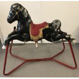 A vintage metal Mobo rocking horse in black with red saddle and frame.