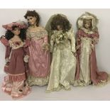 Four modern ceramic collectors dolls in period style clothing.