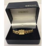 A boxed ladies Seiko wristwatch with gold tone linked bracelet.