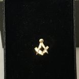 A 9ct gold Masonic set square and compass shaped tie pin.