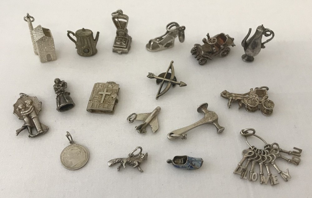 A collection of silver and white metal vintage charms.