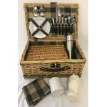 A modern wicker picnic set for 2 to include crockery, cutlery, glasses and a thermos flask.