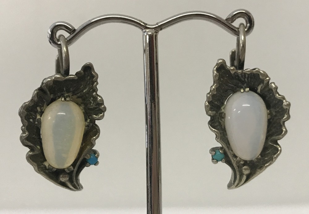 A pair of white metal Art Nouveau style flower design earrings set with moonstones and turquoise.