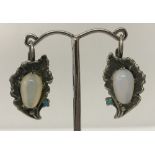 A pair of white metal Art Nouveau style flower design earrings set with moonstones and turquoise.