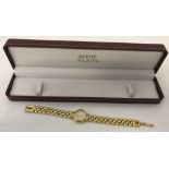 A boxed ladies quartz watch with gold tone bracelet by Annie Klein.
