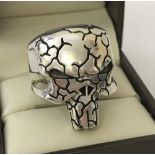 A men's large silver crackle design skull shaped ring.