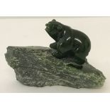 A carved Nephrite jade bear standing on natural jade platform.