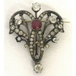 A French silver Art Nouveau brooch set with red and clear stones.