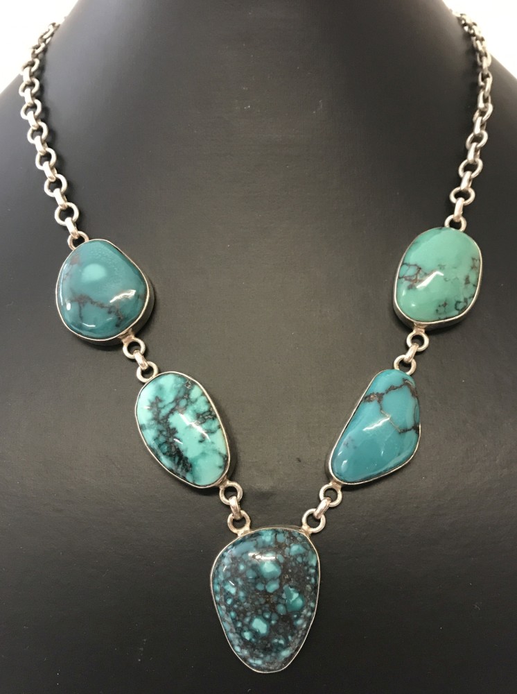 A modern design silver necklace set with 5 large turquoise stones.