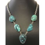 A modern design silver necklace set with 5 large turquoise stones.