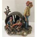 A large Capo Di Monte La Burla figural group of a old man standing and two young boys in a barrel.