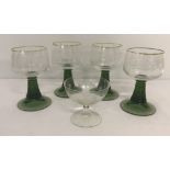 A box of 4 engraved hock glasses with green stems.